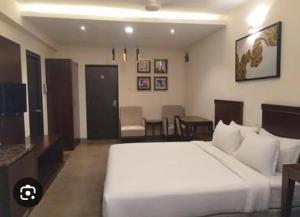 ein Schlafzimmer mit einem großen weißen Bett in einem Zimmer in der Unterkunft Madras Heights in Chennai