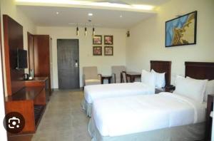 ein Hotelzimmer mit zwei Betten und einem Fernseher in der Unterkunft Madras Heights in Chennai
