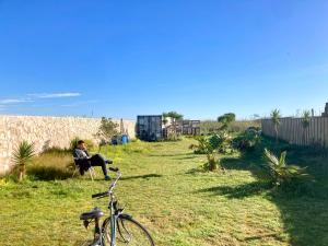 a man sitting in a chair in a yard with a bike at early afternoon Boutique Stay in Ferrel +1 photo
