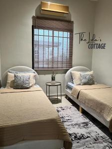 two beds sitting in a room with a window at The LuLas Cottage in Malacca