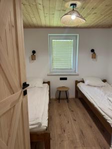 a room with two beds and a window at Domki przy lesie 300m od jeziora 509-619-803 in Zawóz