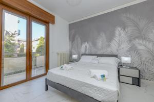 リヴォルテッラにあるMGH My Desenzano Center Apartmentのベッドと大きな窓のある寝室