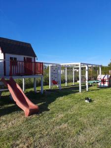 a park with a playground with a slide at Osada Szwedzka Domek Plus in Rusinowo