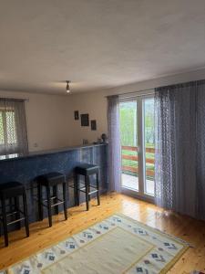 a living room with a bar with stools and a window at Lake House Ceric in Jajce