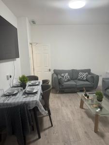 a living room with a couch and a table at Britlodge Ruskin Ave Home in Manchester