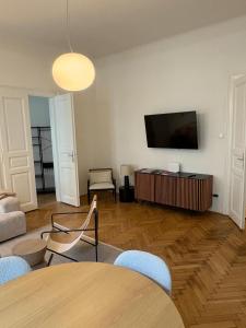 a living room with a television and a table and chairs at Premium Apartment in Altstadtnähe in Graz