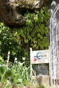 a sign on the side of a wall with plants at Kamakura Jomyoji Terrace-鎌倉浄明寺テラス- in Kamakura