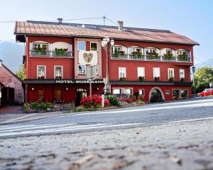 a red building on the side of a street at Hotel Rossmann in Greifenburg
