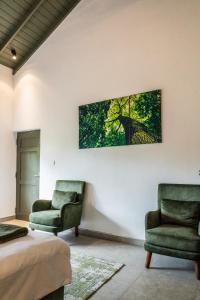 two chairs and a bed in a room at Villa Apsara by Avant Leisure in Aluthgama