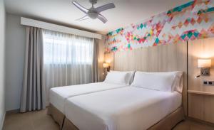 a bedroom with a large white bed and a window at Allegro Isora in Puerto de Santiago