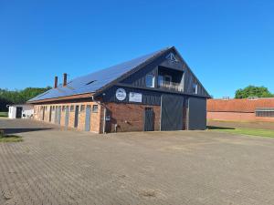 a large brick building with a black roof at Pelster´s Apartments in Diepholz