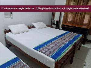 una camera da letto con un letto grande con due cuscini di AHSRAM Accommodations a Pasikuda
