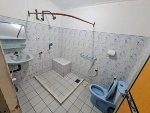 bagno con servizi igienici blu e lavandino di AHSRAM Accommodations a Pasikuda