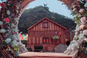 a wooden barn with a table in front of it at Bắc Hà Green Homestay & Coffe in Kon Rung (1) +1 photo