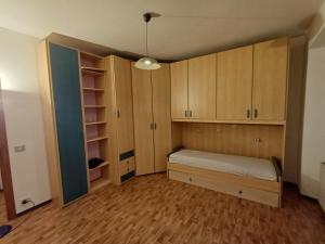 an empty room with a bed and wooden cabinets at Casa Sinetta Como Lake in Acquaseria