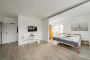 ein weißes Schlafzimmer mit einem Bett und einem Tisch in der Unterkunft Schönbrunn (07): 3-Personen Wohnung nahe Gloriette in Wien