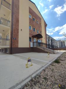 a building with two yellow barricades in front of it at Apartman Nina in Ostrovo