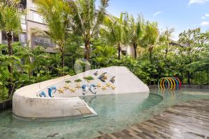 un tobogán en medio de una piscina en Alva by Kozystay - Nusa Dua, en Nusa Dua
