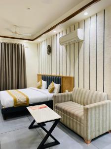 a hotel room with a bed and a couch at Rosewood Grand in Faridabad