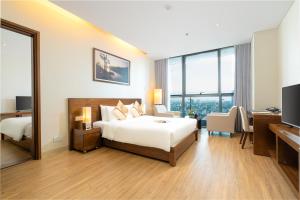 Cette grande chambre comprend un lit et un bureau. dans l'établissement Grand Tourane Hotel Da Nang, à Đà Nẵng