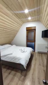 a bedroom with a large bed with a wooden ceiling at Vila Vlajić 2020 in Gornje Pale