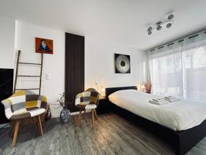 una camera con un letto e una scala e due sedie di La détente marocaine studio jacuzzi et terrasse a Reims