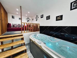 una vasca idromassaggio in una camera con divano di La détente marocaine studio jacuzzi et terrasse a Reims Altre 17 foto
