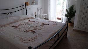 a bed with a white bedspread with a design on it at Da Lucia in Francavilla al Mare