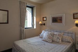 ein Schlafzimmer mit einem Bett mit Kissen und einem Fenster in der Unterkunft Villa San Massimo by Wonderful Italy in Rapallo