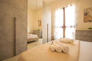 ポザーダにあるBeach Apartment, comodo tra il centro e il mareのベッドの上に3枚の巻かれたタオルが置かれたバスルーム