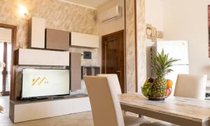 ポザーダにあるBeach Apartment, comodo tra il centro e il mareのテーブルとテレビのあるキッチンとダイニングルーム