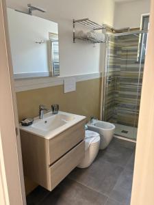 une salle de bain avec un lavabo, des toilettes et une douche dans l'établissement Eolia Rooms, à Lipari