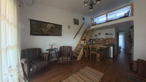 a living room with a staircase and a table and chairs at Ana Maria Boutique House in Samothraki