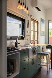 una cucina con armadi verdi e lavandino di Folktales Rest - Tiny House Unique Stay a Esperance