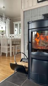 einen Kamin im Wohnzimmer mit einem Tisch in der Unterkunft La Casa Senja in Håverjorda