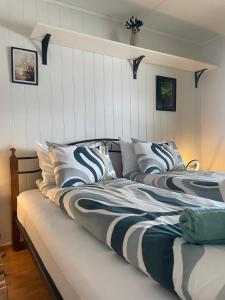two beds in a room with white walls at La Casa Senja in Håverjorda