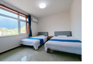 Un pat sau paturi într-o cameră la Gubeikou Great Wall Juxian Residents' Lodging