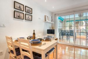 ein Esszimmer mit einem Tisch und einer Flasche Wein in der Unterkunft La Terraza De Palmeres in Mareny Barraquetas