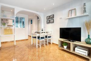 ein Wohnzimmer mit einem TV und einem Esszimmer in der Unterkunft La Terraza De Palmeres in Mareny Barraquetas + 17 Fotos