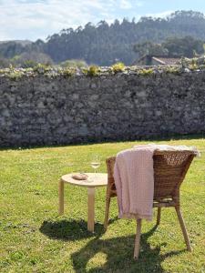 a table and a chair with a glass of wine at Casa El Lloréu in Naves +25 photos