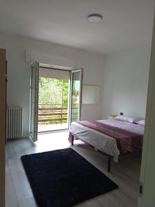 a bedroom with a bed and a sliding glass door at Villa la Palma in Gemonio +56 photos