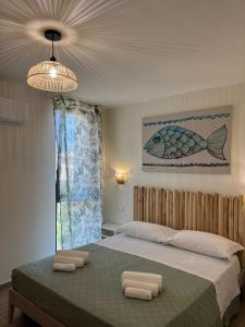a bedroom with a large bed with two towels on it at le suite dell'isola in Oliveri