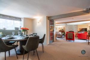 a dining room with a table and chairs and a living room at Bay Tree Cottage in Burton Bradstock