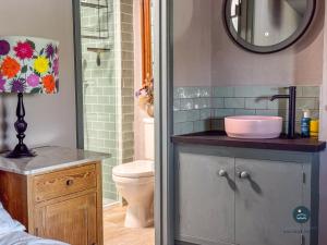 a bathroom with a sink and a toilet and a mirror at Bay Tree Cottage in Burton Bradstock +14 photos
