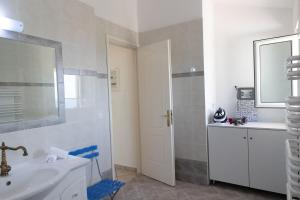 a white bathroom with a sink and a mirror at Aethra Villa in Sounio +27 photos