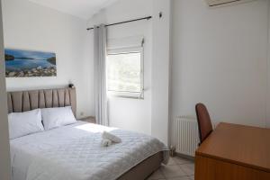 a bedroom with a bed with a stuffed animal on it at Aethra Villa in Sounio