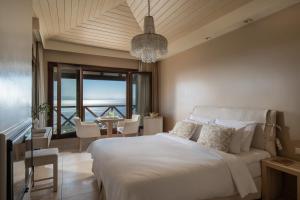 a bedroom with a large bed and a dining room at Karavia Lux Inn in Afissos +61 photos