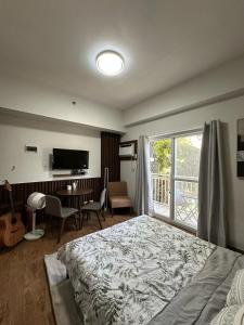 a bedroom with a bed and a desk and a television at JNest Cozy Condo Bldg A 215 in Lapu Lapu City +13 photos
