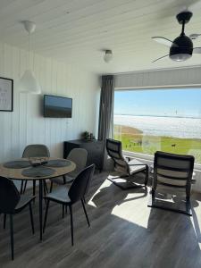 a living room with a table and chairs and a large window at Aitvarai 41 in Svencelė