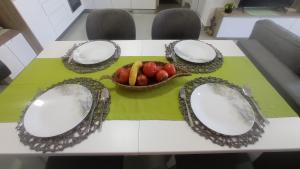 a table with plates and a bowl of fruit on it at Golem Horizon apartment in Golem